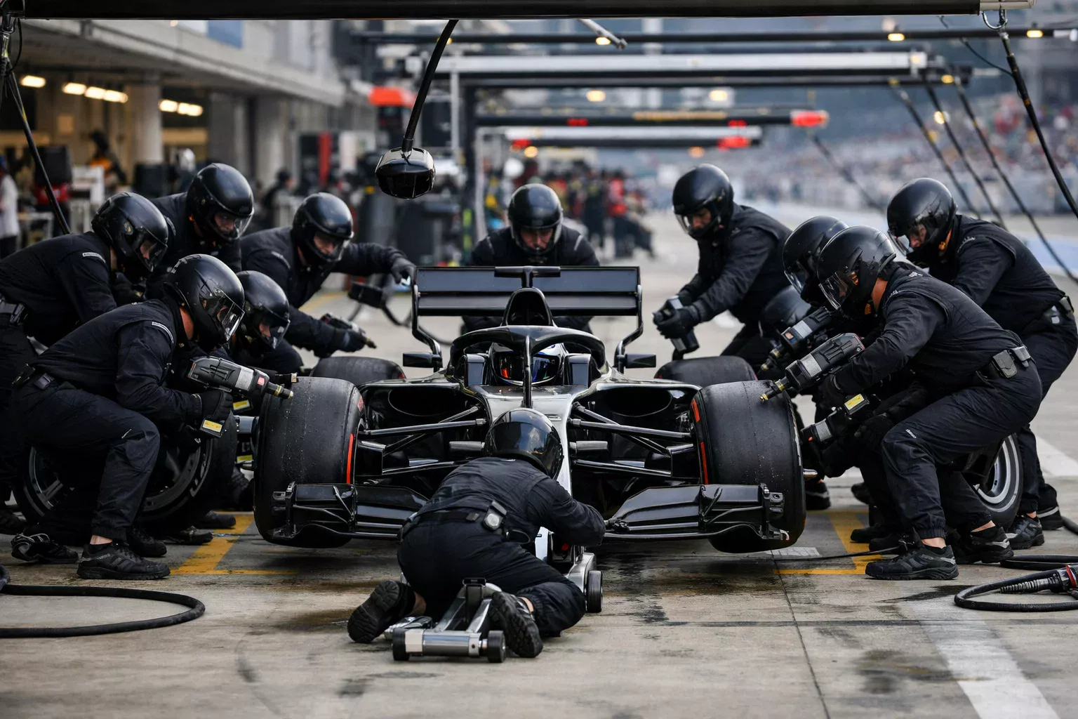 Nahaufnahme eines Formel-1-Reifenwechsels beim Boxenstopp mit Mechanikern
